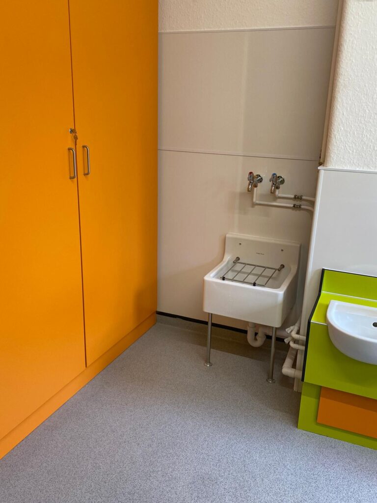 Bespoke cupboard in Orange and cleaners sink